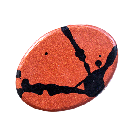 Oval orange bonbon with black abstract design on a white background