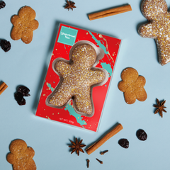 Kate Weiser's Gingerbread man cookie cutter with gingerbread cookies and spices on a blue background