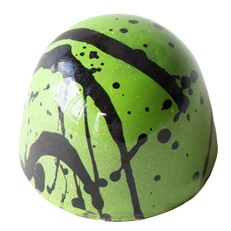 Green bonbon with black splatter design on a white background