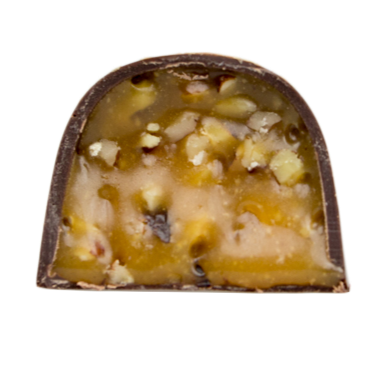 Chocolate bonbon cut in half filled with caramel and pecans