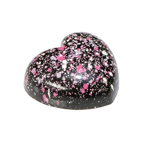 Heart-shaped bonbon with black background and pink and white speckles