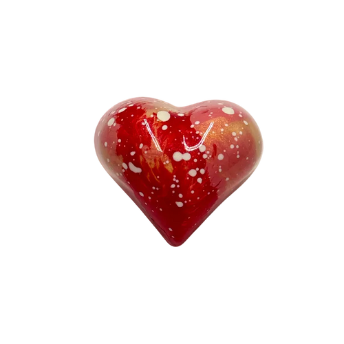 Red heart-shaped bonbon with white speckles on a white background