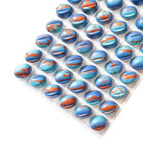 Pack of blue and orange marbled chocolates in a white tray